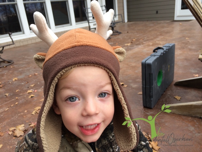 child with deer hat