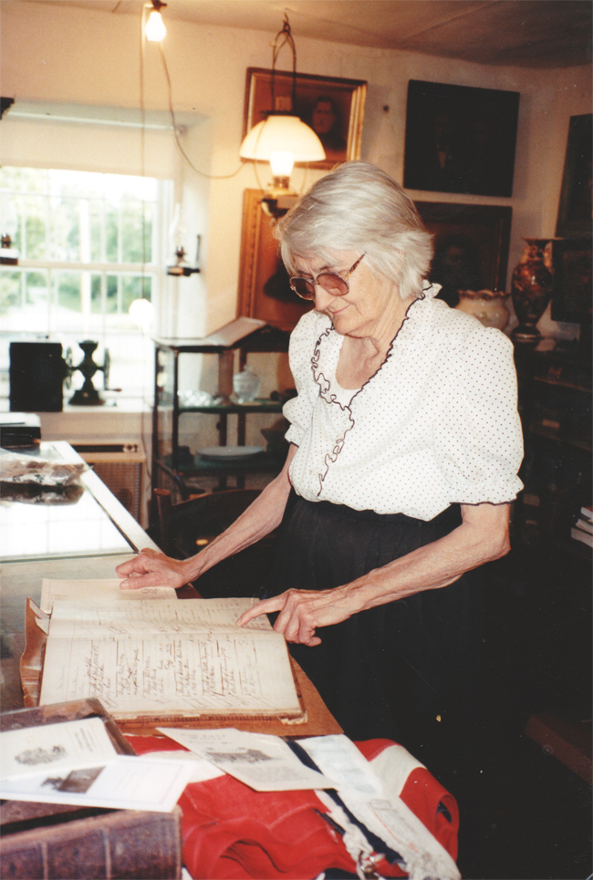 Ethelyn Ammerman looks at records book from Pay Down General Store and Mill