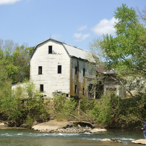 Cedar Hill Mill and man fishing from dam