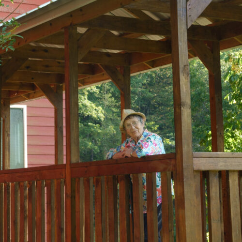 Rita Fancher leaning on railing at Rockbridge Mill